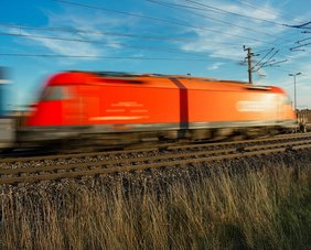 Rote Lokomotive auf Bahngleisen mit Bewegungsunschärfe