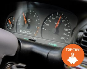 Tachometer, Drehzahlmesser und weitere Anzeigen eines PKWs, davor ein oranges Icon mit einem weißen Sparschwein, Bild symbolisiert Spritspar-Tipps