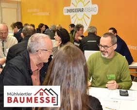 Energieberater des OÖ Energiesparverbandes berät einen Mann und eine Frau auf einer Messe. Links unten das Logo der Mühlviertler Baumesse 2026
