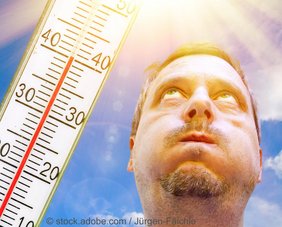 Mann blickt in die Sonne, daneben ein Thermometer mit über 40 Grad Celsius