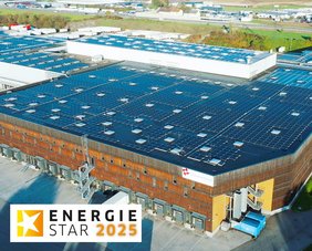 Das Firmengebäude, eine große Halle, der Firma Schachinger Logistik, von oben aufgenommen, mit einer sehr großen PV-Anlage am gesamten Hallendach.